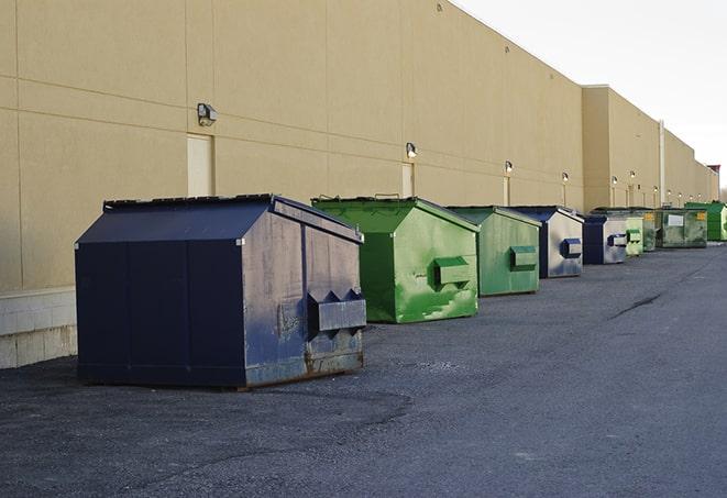 construction workers toss wood scraps into a dumpster in Canton